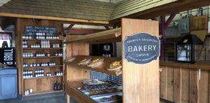 The entrance of the bakery with pies and fruit preserves on shelves.