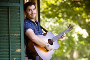 Singer sam Miller posing with his guitar