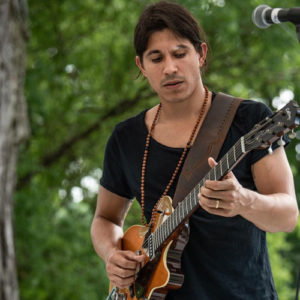 Jose Lopez playing guitar outdoors